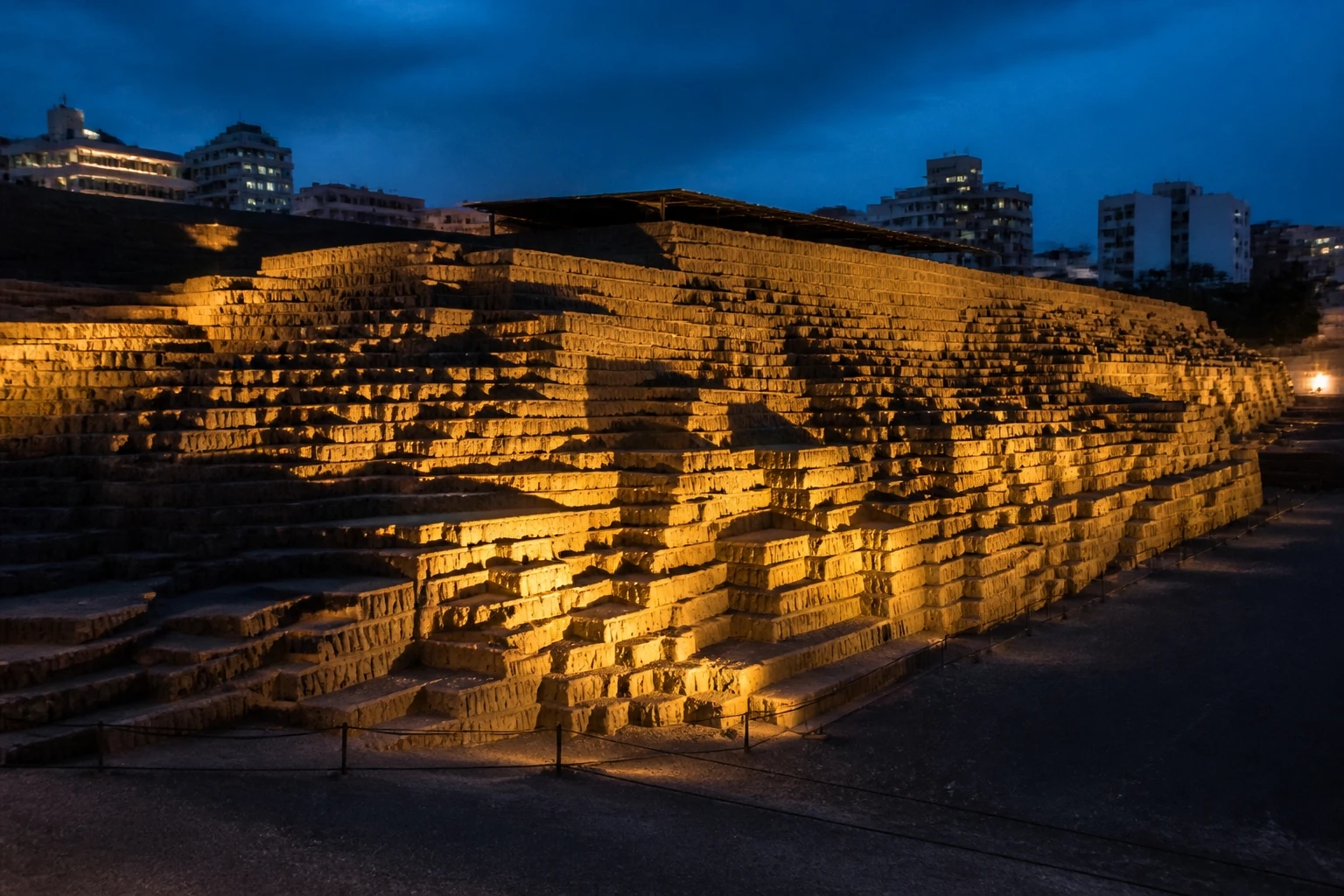Illuminated adobe terraces at Huaca Pucllana during an evening visit