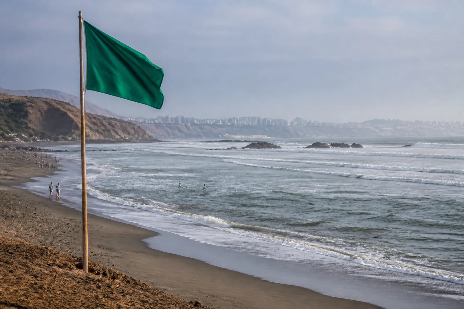 Green beach safety flag by the sea in Lima